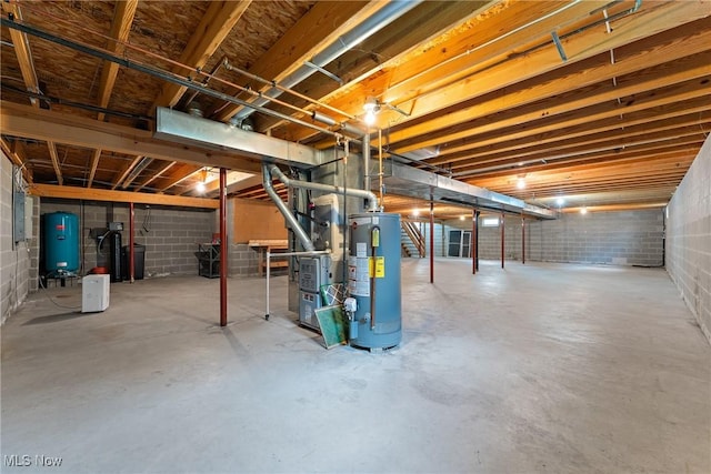 unfinished below grade area featuring heating unit, concrete block wall, and gas water heater