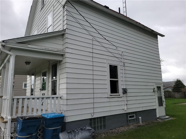 view of property exterior with a porch and a lawn