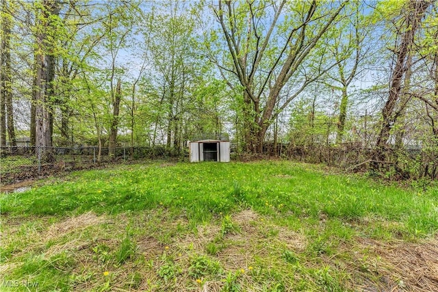 view of yard featuring a storage unit, a fenced backyard, and an outbuilding