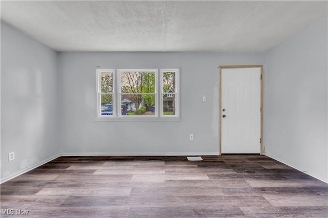 empty room featuring baseboards and wood finished floors