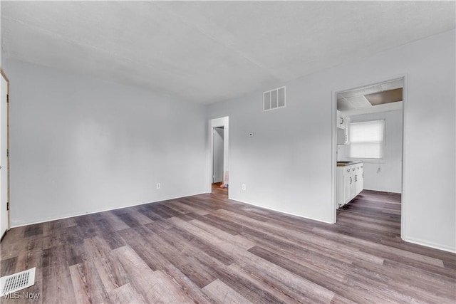 unfurnished living room featuring visible vents and wood finished floors