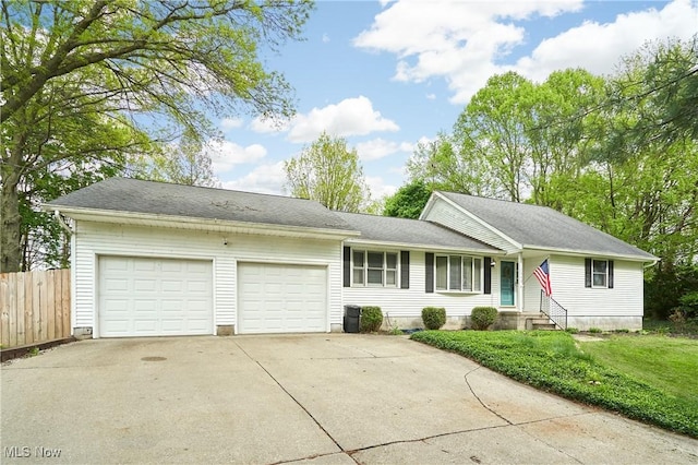 view of front of house with concrete driveway, a front yard, an attached garage, and fence