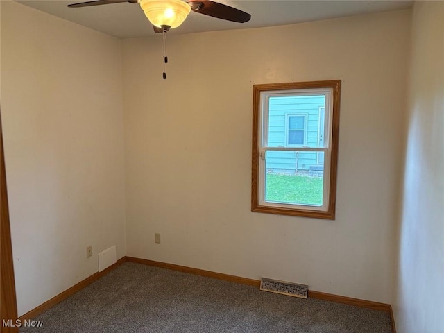 empty room featuring carpet, baseboards, a ceiling fan, and visible vents