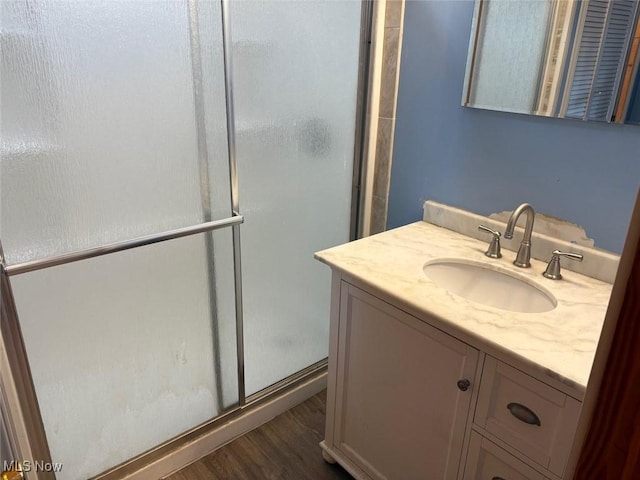 bathroom featuring a shower stall, vanity, and wood finished floors