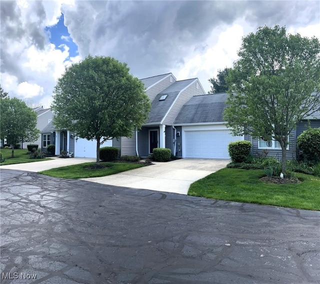 view of front facade featuring a garage, a front lawn, and driveway