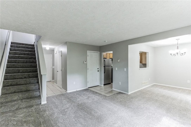 unfurnished living room featuring light colored carpet, stairs, baseboards, and an inviting chandelier