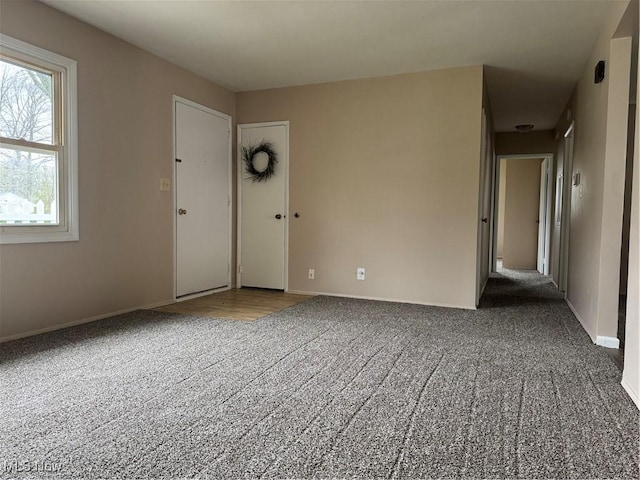 carpeted spare room with baseboards