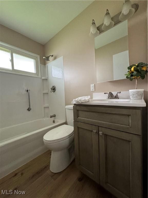 full bath with toilet, vanity, bathtub / shower combination, and wood finished floors