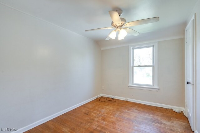 empty room featuring ceiling fan, light wood-style flooring, and baseboards