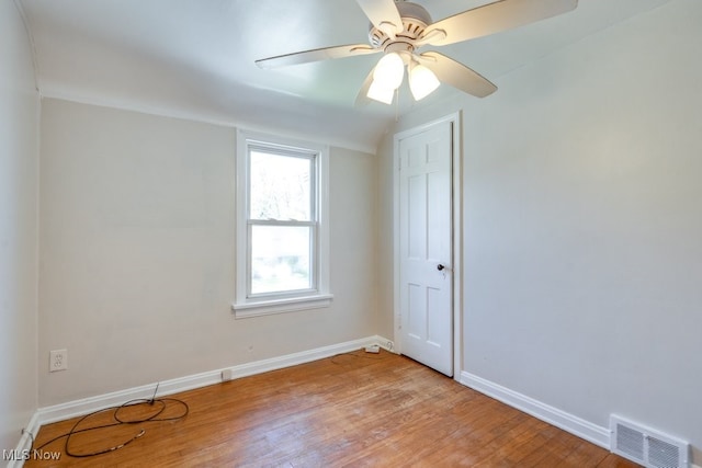 unfurnished room with baseboards, a ceiling fan, visible vents, and light wood-style floors