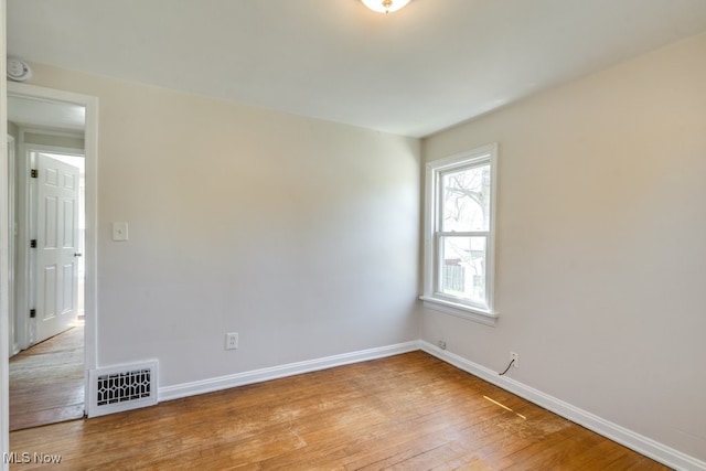 spare room with baseboards, visible vents, and light wood-style floors