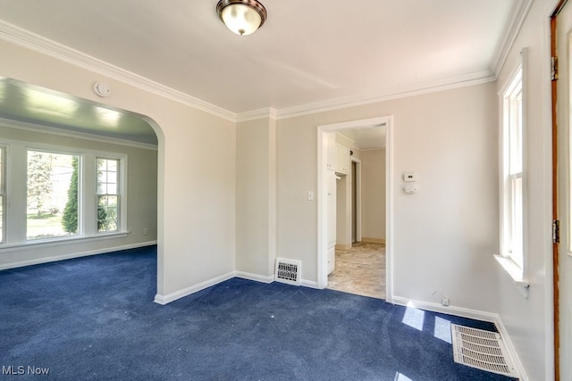 unfurnished room with arched walkways, crown molding, and carpet