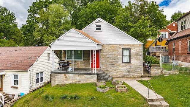 2007 Carson St, Charleston, WV 25302 - bungalow-style home with stone siding, a vegetable garden, a front lawn, and fence