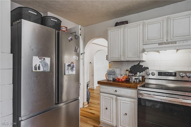 2007 Carson St, Charleston, WV 25302 - kitchen with under cabinet range hood, wooden counters, arched walkways, light wood-style floors, and stainless steel appliances