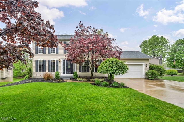 colonial home featuring concrete driveway, a front yard, and a garage