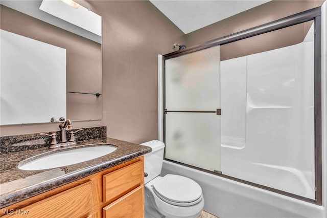 bathroom featuring enclosed tub / shower combo, vanity, and toilet