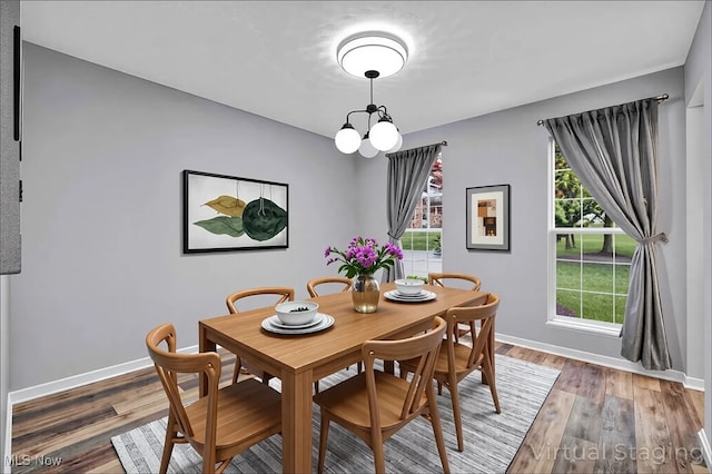 dining area with baseboards, light wood-style floors, and an inviting chandelier