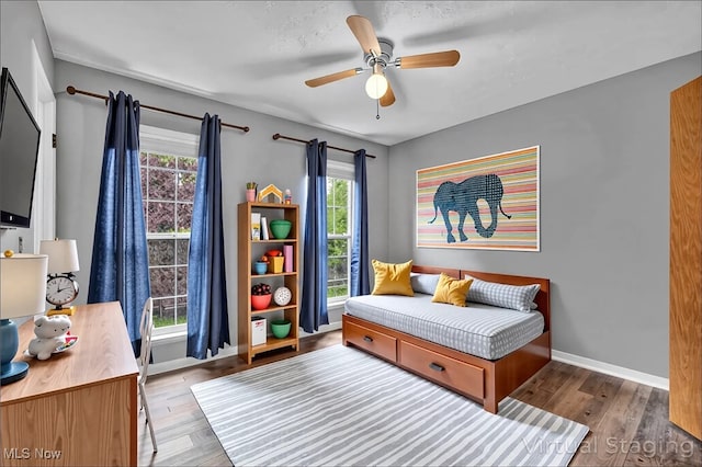 bedroom featuring baseboards, a ceiling fan, and wood finished floors