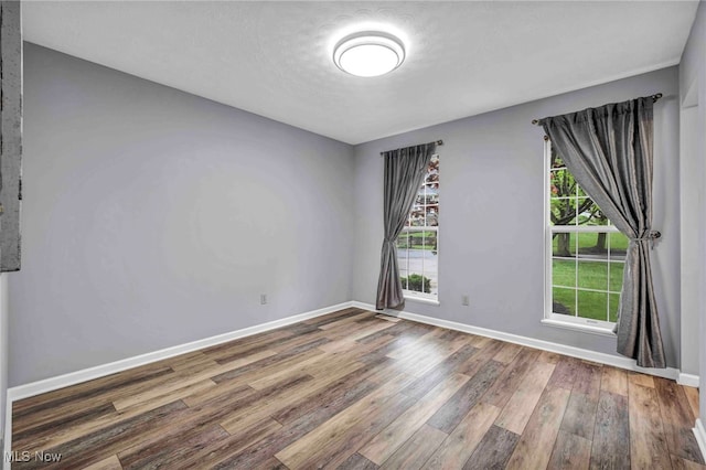 unfurnished room featuring baseboards and wood finished floors