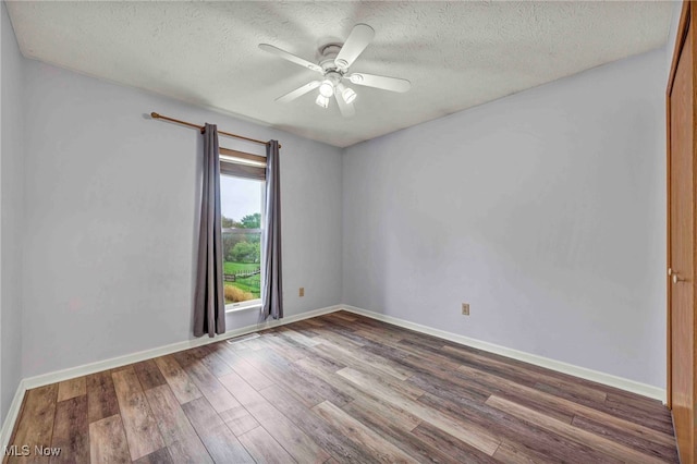 spare room with a ceiling fan, baseboards, a textured ceiling, and wood finished floors