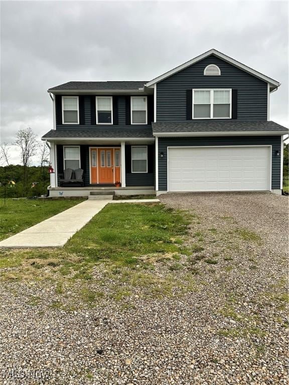 11149 Rankin Rd, Glenford, OH 43739 - view of front of house featuring driveway, an attached garage, covered porch, and a front lawn