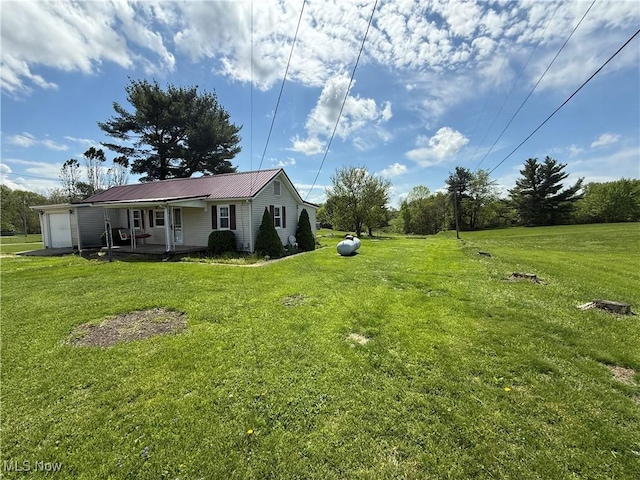 view of yard with covered porch and an attached garage