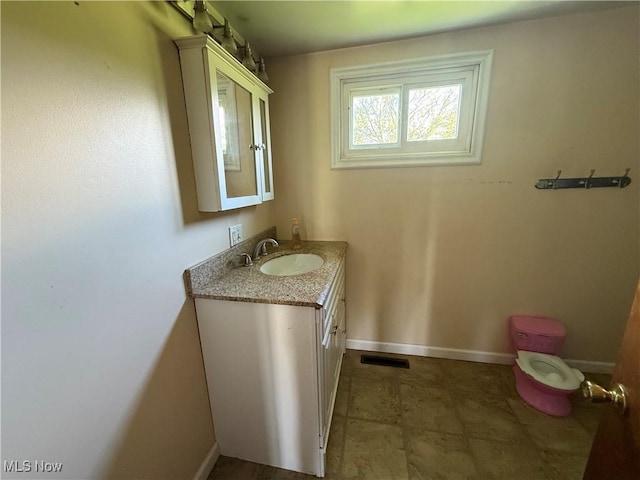 bathroom with baseboards, vanity, and visible vents