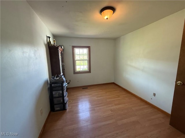 unfurnished room with light wood-style flooring and baseboards