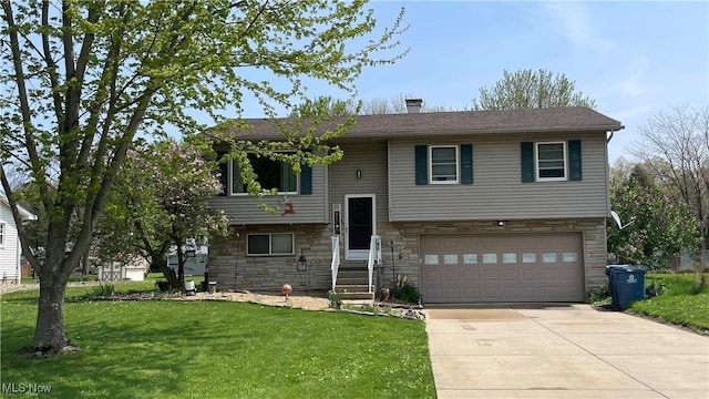 split foyer home with stone siding, concrete driveway, an attached garage, and a front yard