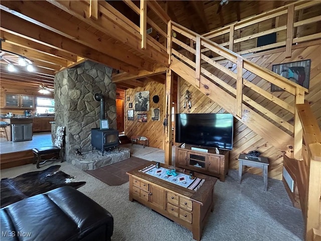 165 Township Rd Unit 1461, Greenwich, OH 44805 - living room with a wood stove, wood walls, ceiling fan, and carpet