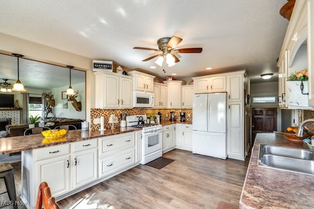 396 2nd St NE, Carrollton, OH 44615 - kitchen featuring white appliances, a sink, a ceiling fan, a fireplace, and wood finished floors