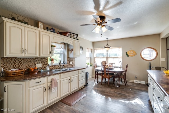 396 2nd St NE, Carrollton, OH 44615 - kitchen featuring a sink, dark countertops, cream cabinetry, baseboards, and ceiling fan