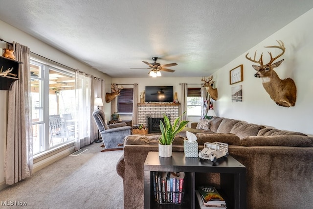 396 2nd St NE, Carrollton, OH 44615 - living room featuring carpet floors, a brick fireplace, ceiling fan, and a textured ceiling