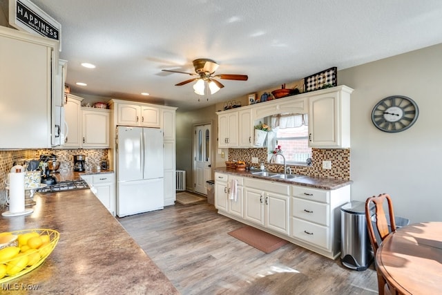 396 2nd St NE, Carrollton, OH 44615 - kitchen with freestanding refrigerator, a ceiling fan, a sink, light wood-type flooring, and decorative backsplash