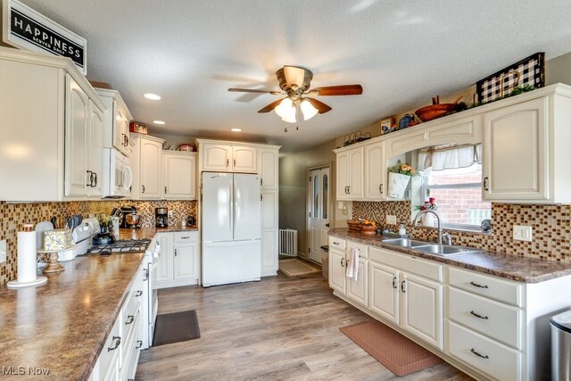 396 2nd St NE, Carrollton, OH 44615 - kitchen featuring white appliances, a sink, radiator heating unit, ceiling fan, and dark countertops