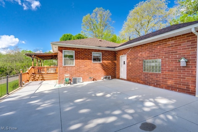 396 2nd St NE, Carrollton, OH 44615 - rear view of property featuring a patio area, brick siding, a shingled roof, and fence