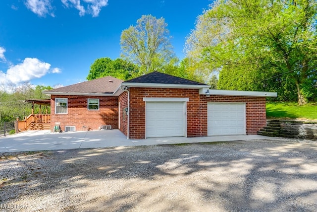 396 2nd St NE, Carrollton, OH 44615 - view of home's exterior with brick siding, a garage, roof with shingles, and driveway