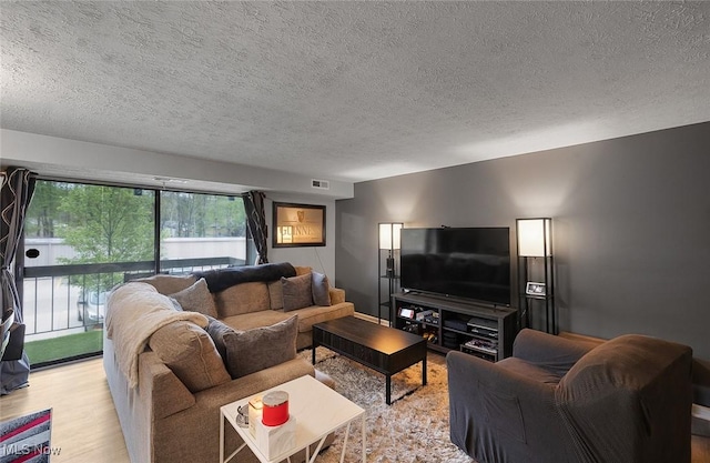 living room featuring a textured ceiling and light wood-style flooring