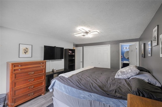 bedroom featuring a textured ceiling, a closet, and light wood-type flooring