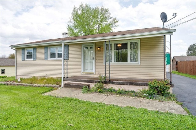 single story home featuring a front yard, driveway, and a chimney