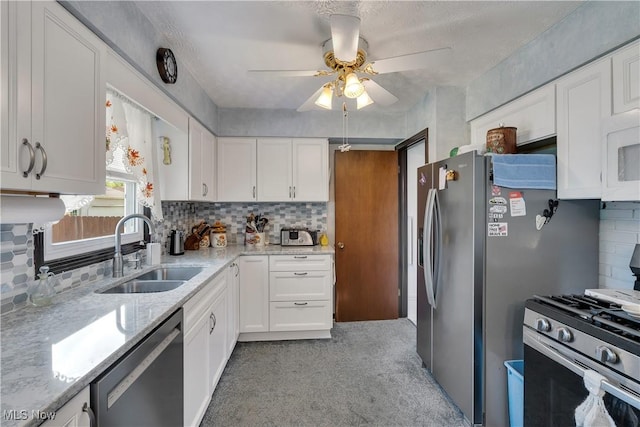 kitchen with stainless steel appliances, a sink, white cabinetry, and ceiling fan