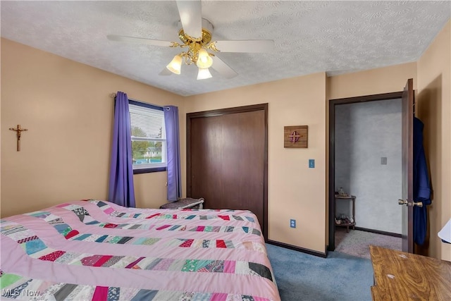 carpeted bedroom with a closet, a textured ceiling, a ceiling fan, and baseboards