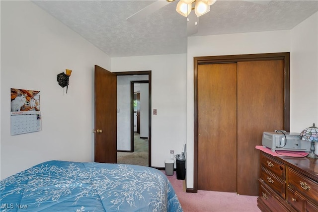 bedroom featuring carpet, a closet, a textured ceiling, and a ceiling fan