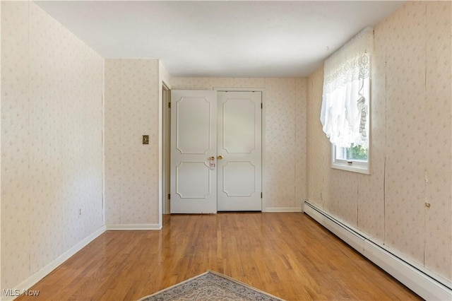 8295 Mentorwood Dr, Mentor, OH 44060 - unfurnished bedroom with baseboard heating and wood finished floors