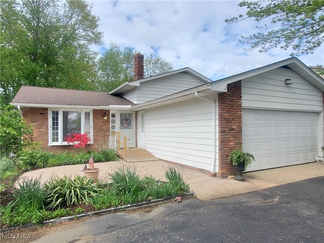 34671 Lake Shore Blvd, Timberlake, OH 44095 - view of front of house with a garage, brick siding, a chimney, and driveway