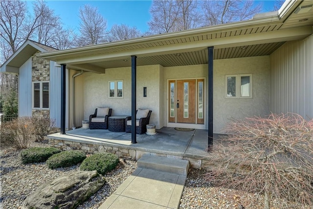 property entrance featuring stucco siding, a porch, and stone siding