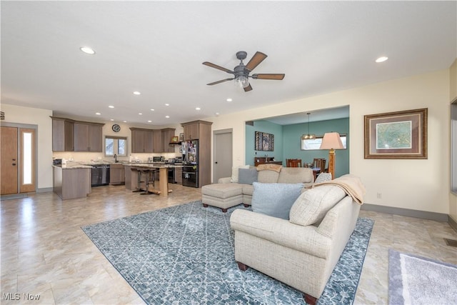 living area with ceiling fan, baseboards, and recessed lighting