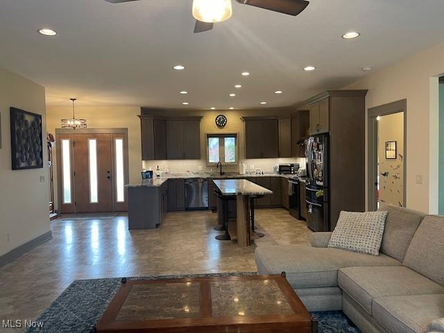 living area featuring ceiling fan, recessed lighting, and baseboards