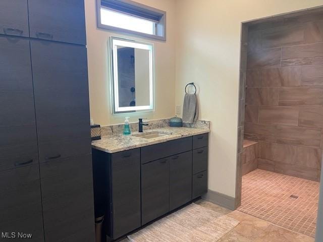 full bath featuring vanity and tiled shower