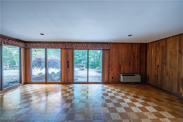 spare room with a wall mounted AC and wood walls